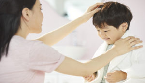 子どもの頭を撫でる母親